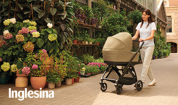 madre paseando con carrito de bebé inglesina con un fondo de puesto de flores
